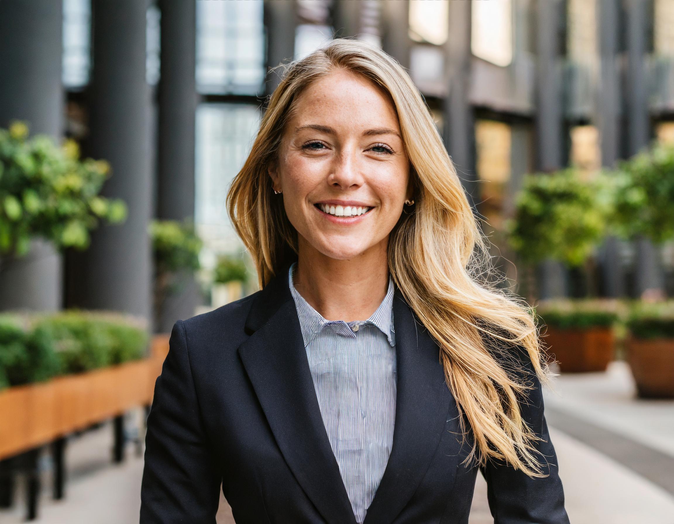 Person in professionellem Büro-Outfit, lächelnd